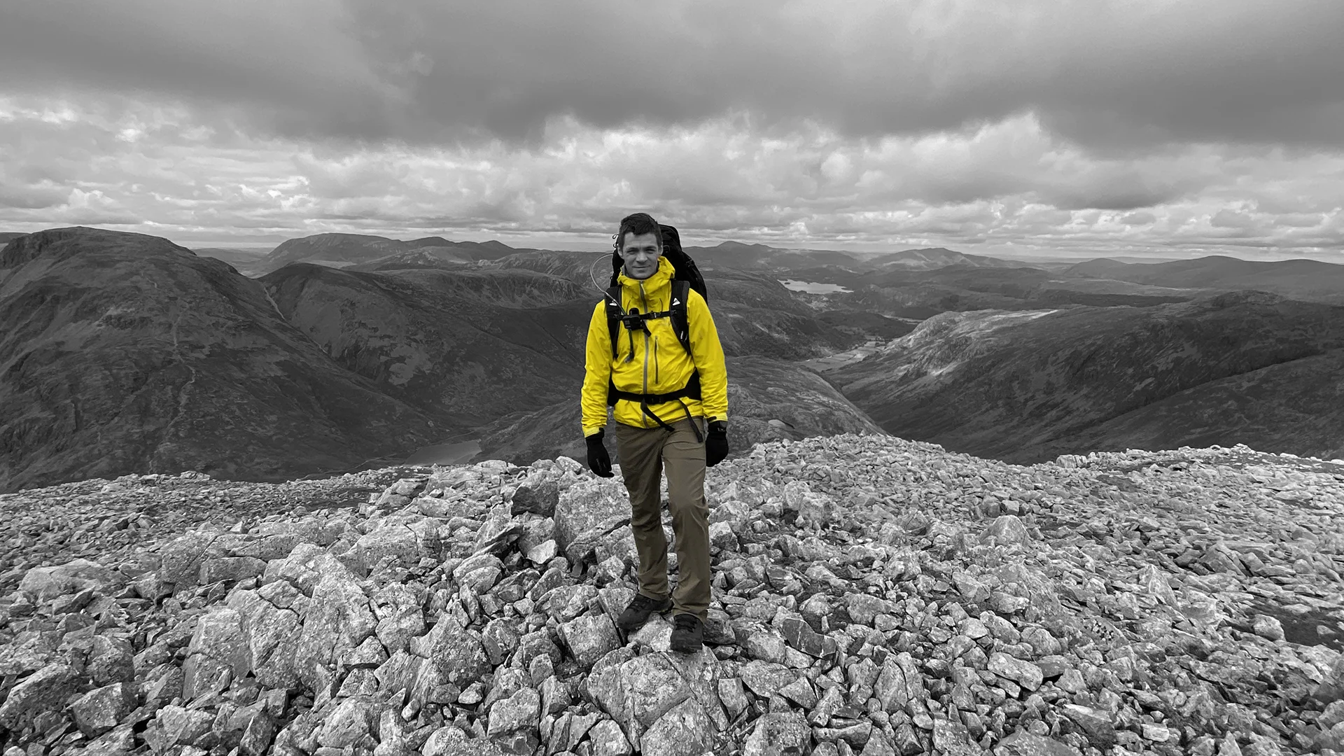 Scott Green standing on a mountain summit overlooking dramatic landscape, outdoor portrait for MUVE®.
